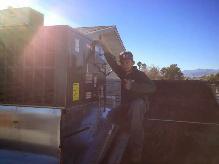 HVAC technician performing HVAC Inspection on a rooftop unit in Peninsula